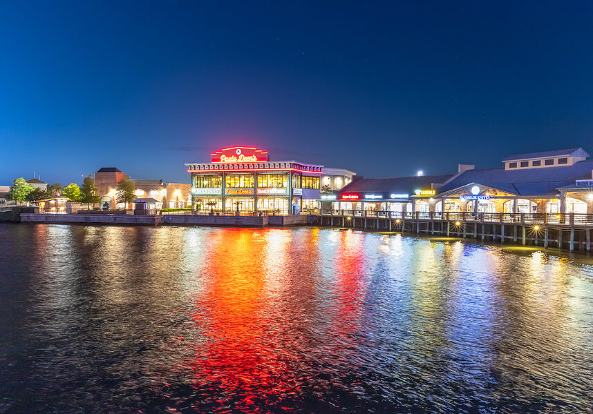 Myrtle Beach, South Carolina: USA, April 28, 2021. A wide angle view of the Boardwalk shopping plaza as viewed from over the lake. Image was taken during twilight hours.